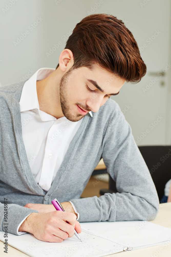 Mann schreibt Prüfung als Student Mann schreibt Prüfung als Student