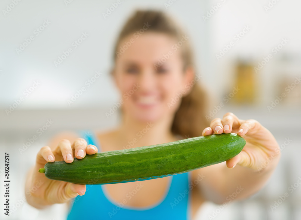 Closeup on cucumber in hand of young woman Closeup on cucumber in hand of young woman
