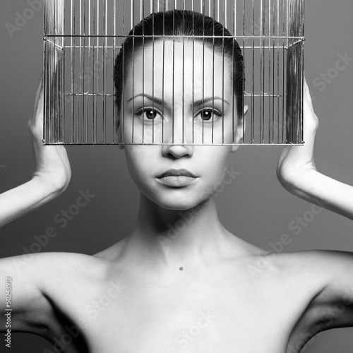 Surrealistic portrait of young lady with cage