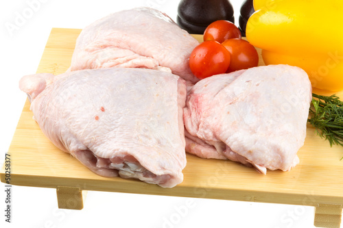 Fresh raw chicken wings on chopping board with roma tomatoes