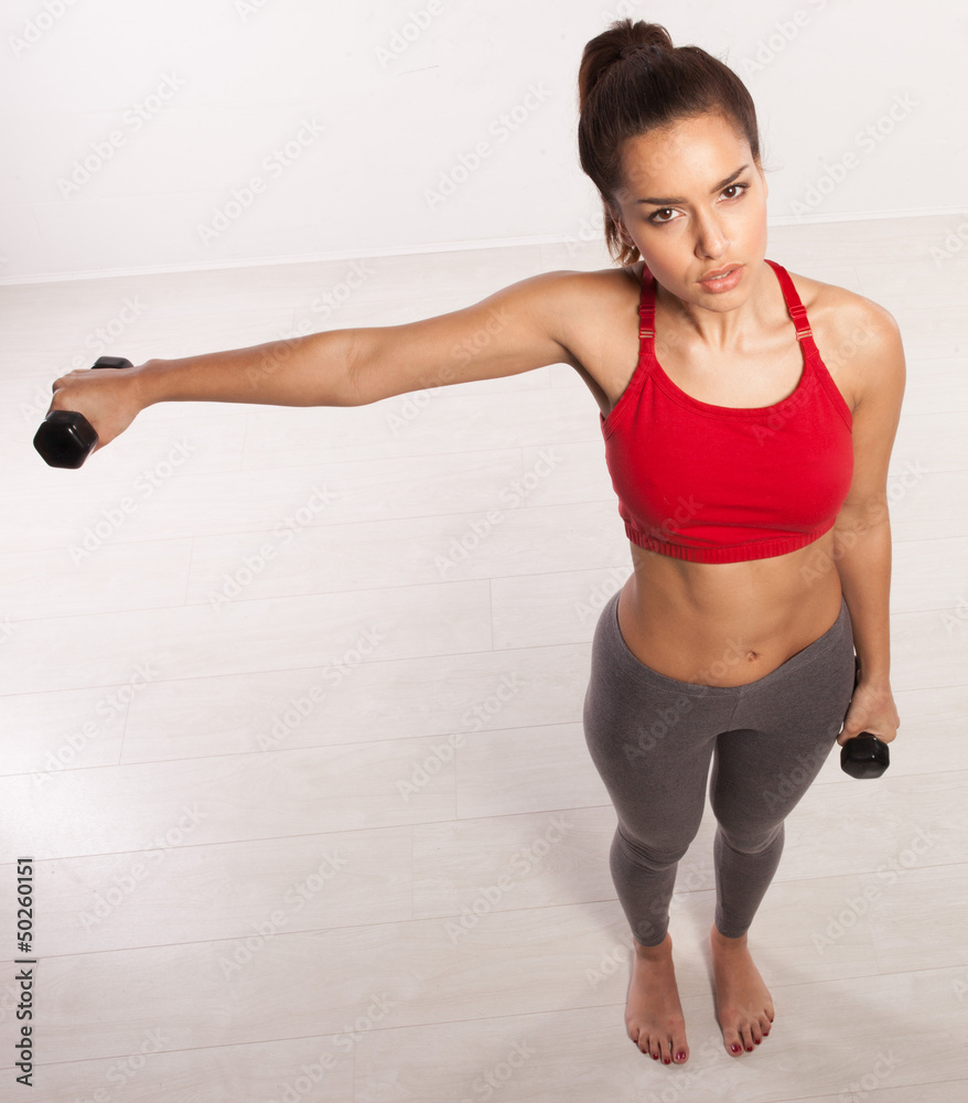 Athletic woman working with dumbbells Athletic woman working with dumbbells