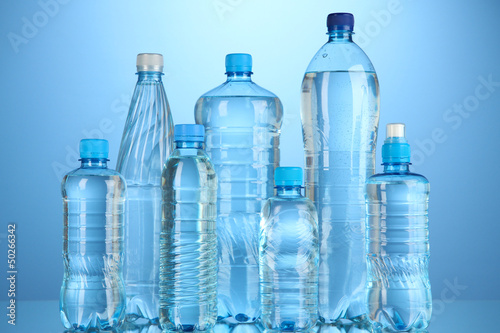 Different water bottles on blue background