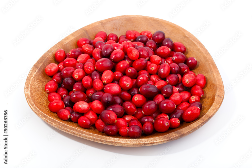 fresh red berries in wooden bowl, isolated on a white background fresh red berries in wooden bowl, isolated on a white background