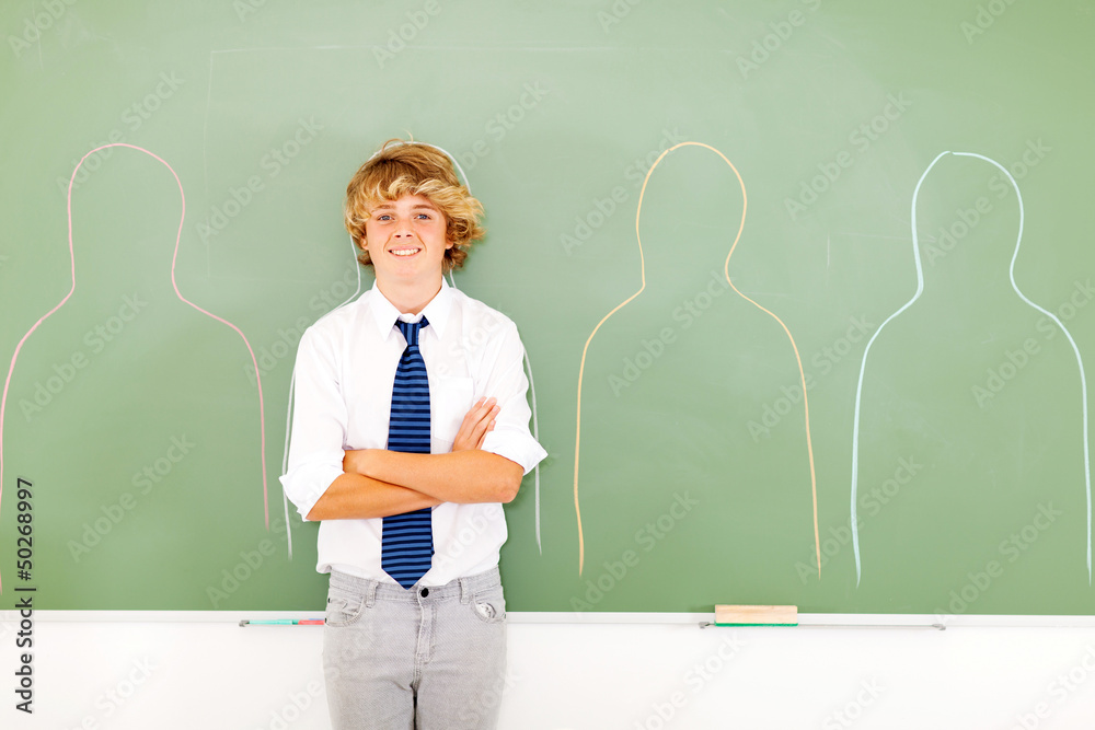 high school teen boy standing in front of chalkboard