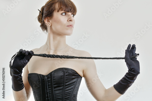 woman in a corset and  riding crop photo
