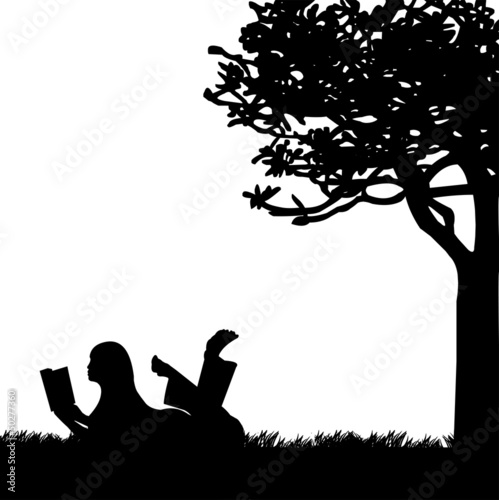 Silhouette of girl reading a book under the tree in spring