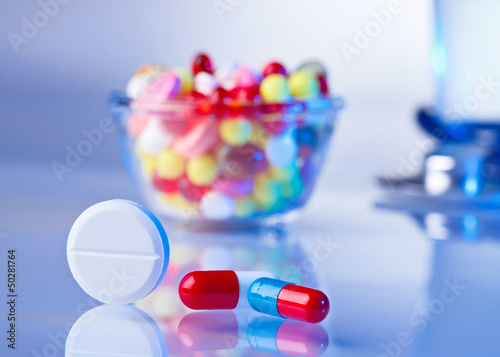 Pills and tablets macro still life on white blue, medical therap photo