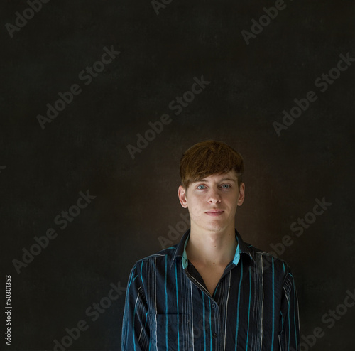 Young business man against a dark blackboard background