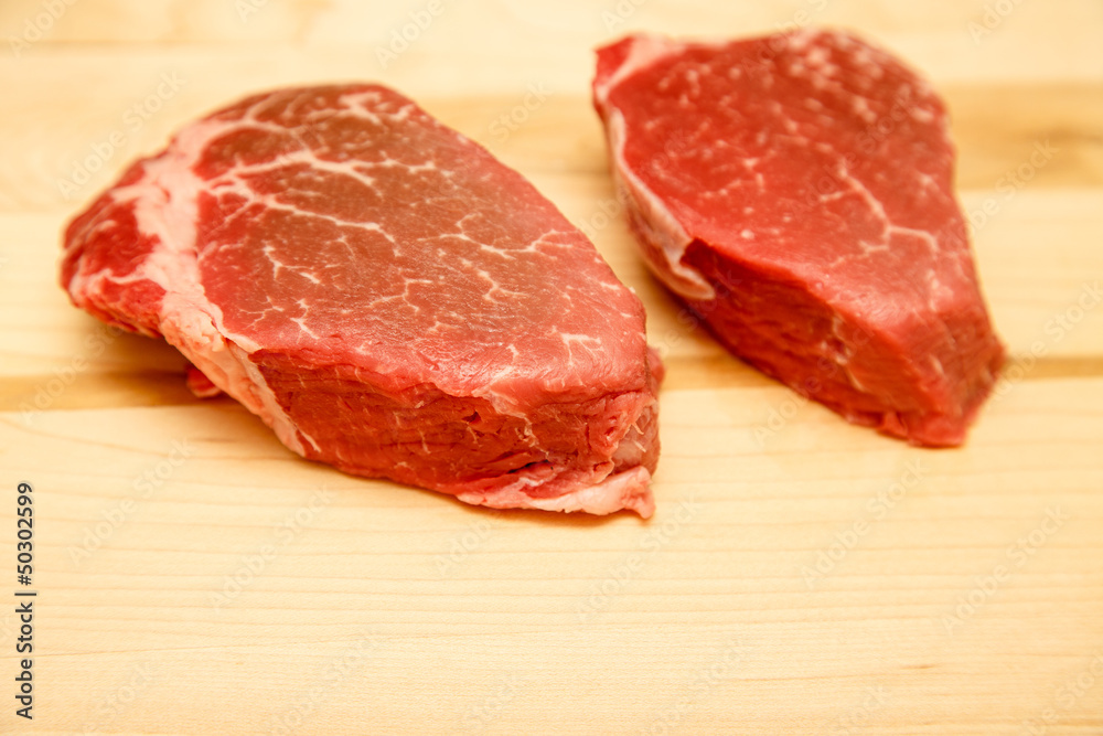 Two Filet Mignon Steaks on Wood Cutting Board