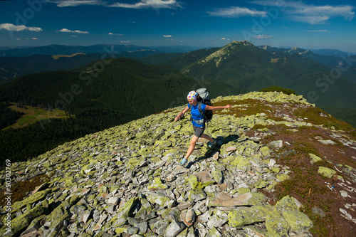 Fototapeta Naklejka Na Ścianę i Meble -  Hiker jumps over stones in Carpathian mountains