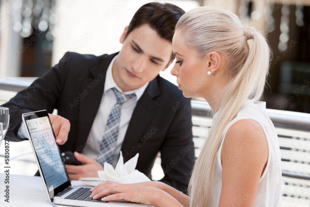 Business partners reviewing work at lunch. Business partners reviewing work at lunch.