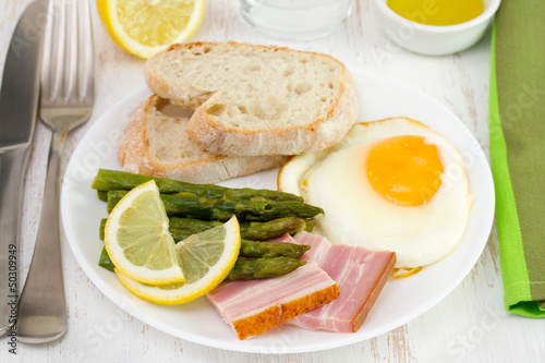 fried egg with bacon and asparagus on the plate