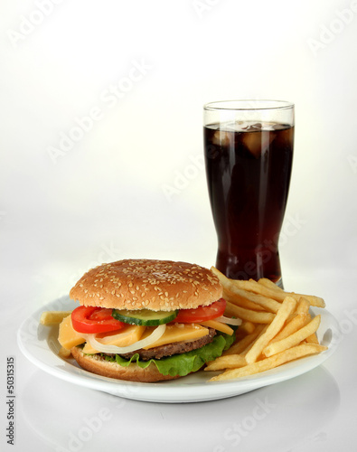 Tasty cheeseburger with fried potatoes and cold drink, isolated