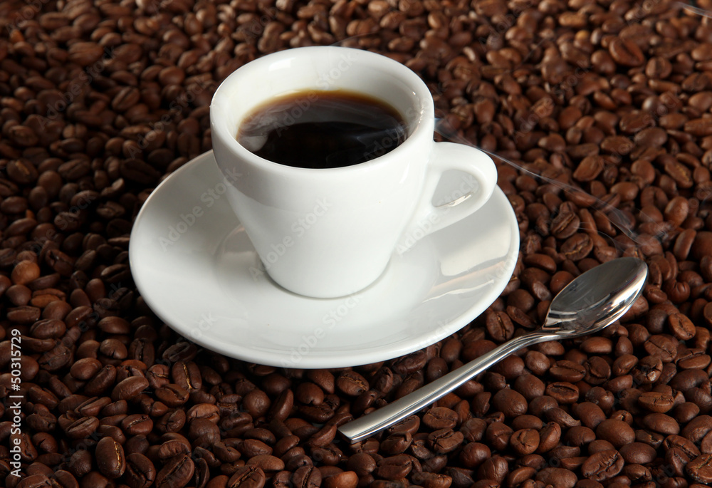 Cup of coffee on coffee beans background Cup of coffee on coffee beans background