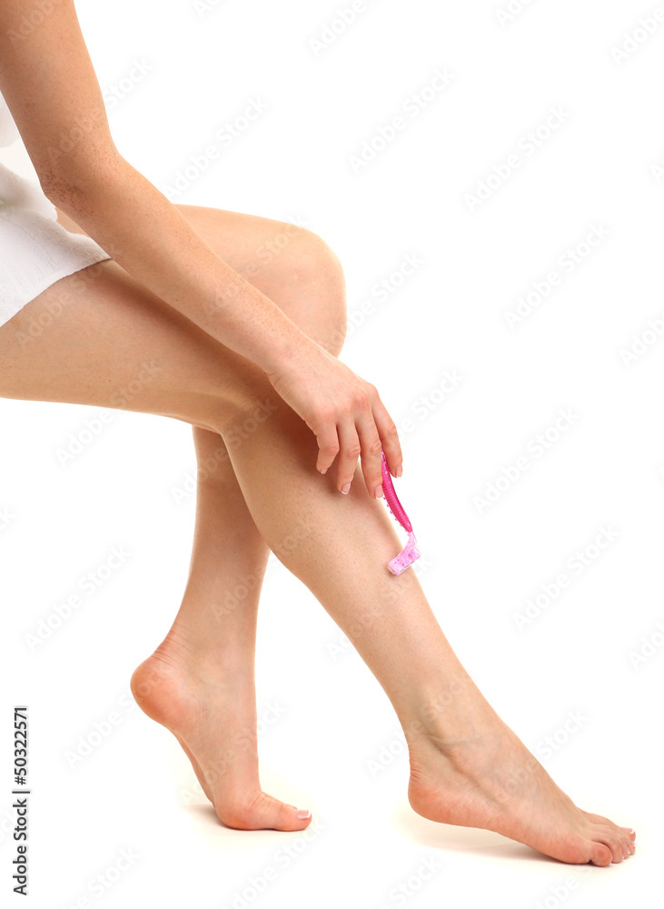 Beautiful woman is shaving her leg, isolated on white Beautiful woman is shaving her leg, isolated on white