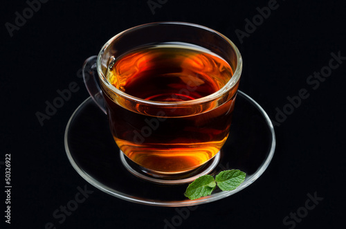 cup of black tea with mint on a black background