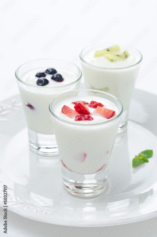 three yogurt with fruit in a glass beaker vertical closeup three yogurt with fruit in a glass beaker vertical closeup