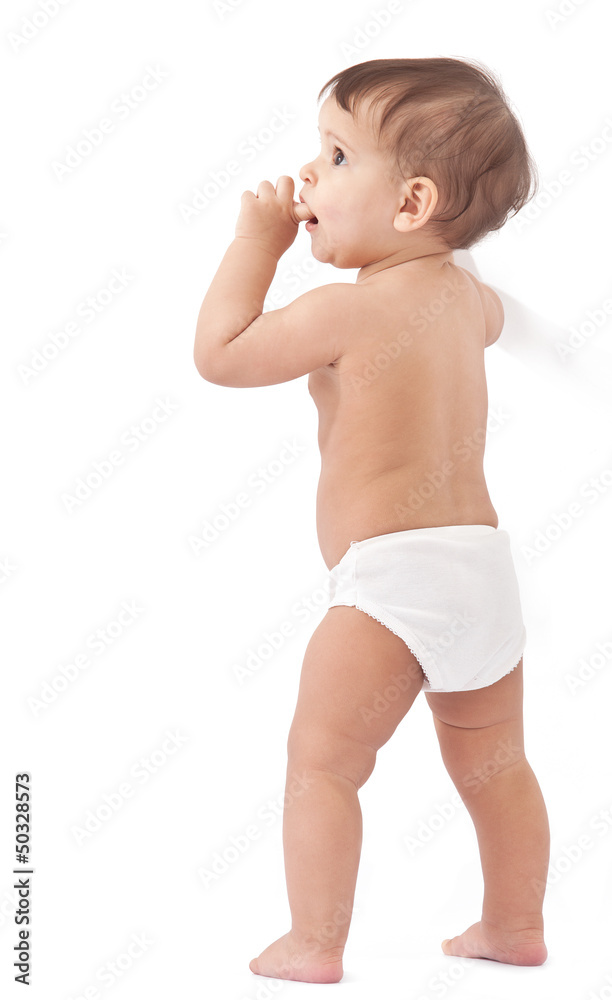 Funny baby stays near wall and holds finger in a mouth. Funny baby stays near wall and holds finger in a mouth.