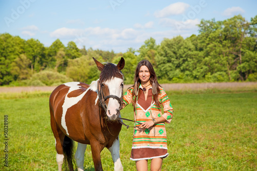 A young girl dressed as an Indian with a paint horse