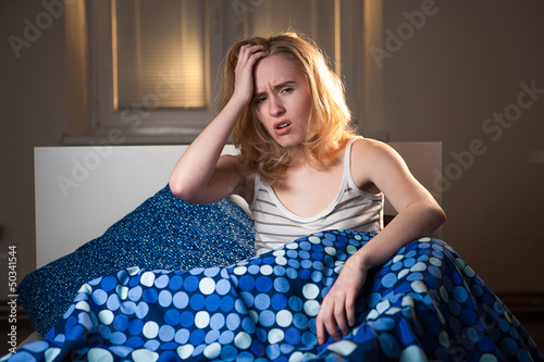 young caucasian woman in bed with headache and hangover