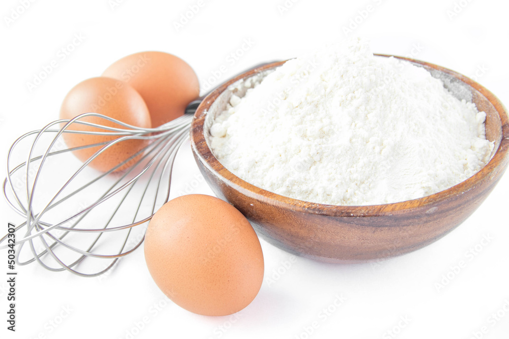 Ingredients for cooking pancakes: eggs, flour and whisk Ingredients for cooking pancakes: eggs, flour and whisk