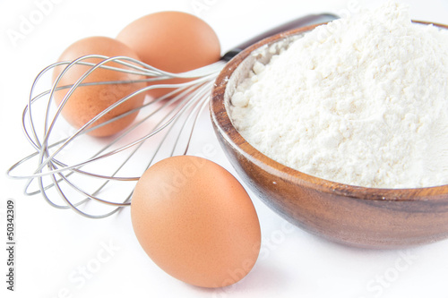 Ingredients for cooking pancakes: eggs, flour and whisk