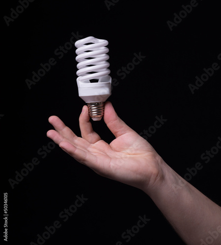 Light bulb in hand on a black background
