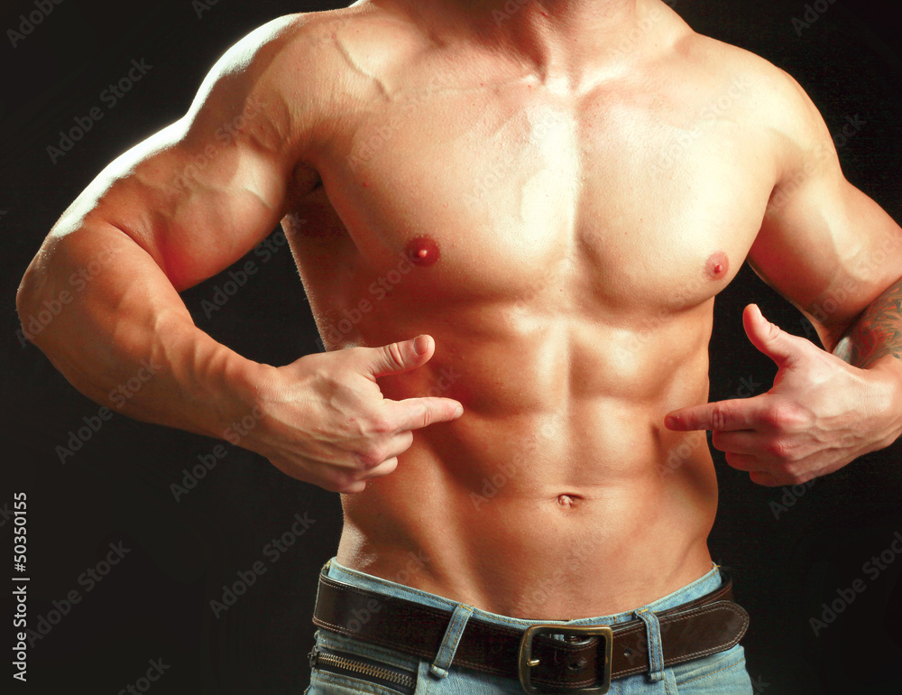 Fototapeta premium Muscular young man showing abs.