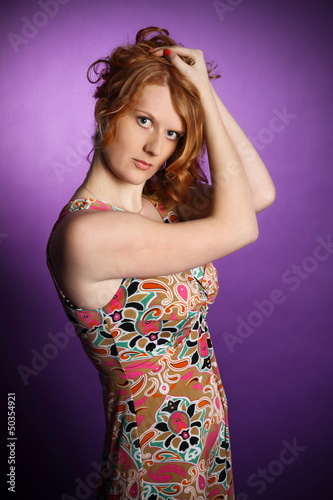Redhead in a dress on a violet background