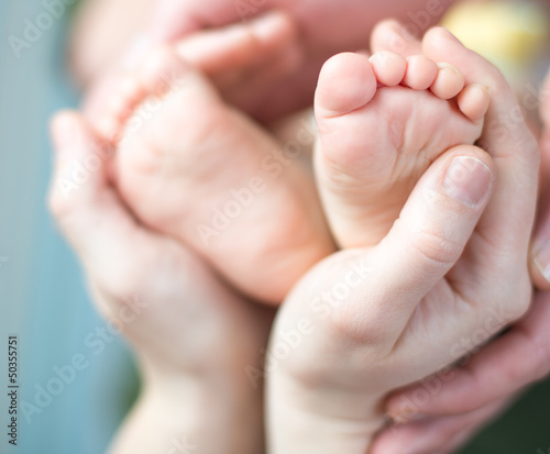 Parents holding feet of his newborn son