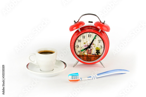 Red alarm clock, coffee and a toothbrush
