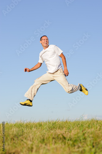 man jumping on green field photo