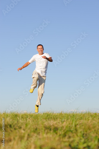 man jumping on green field photo