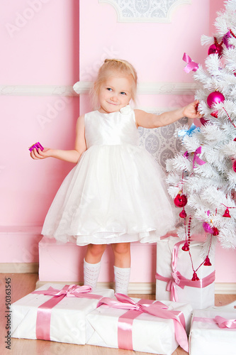 The girl at the Christmas fir-tree with gifts