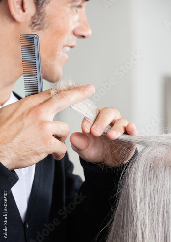 Hairdresser Cutting Senior Woman's Hair At Salon