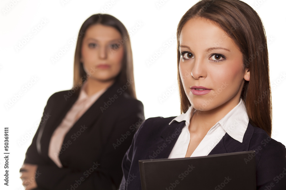 Two business women posing on white background Two business women posing on white background