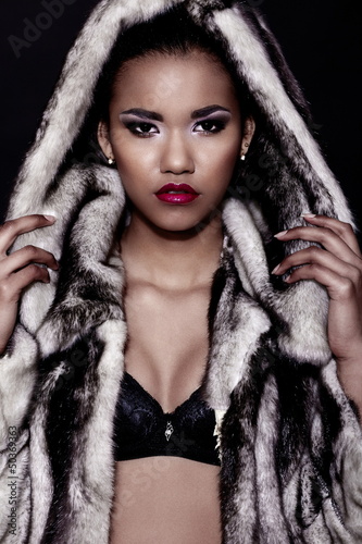 black woman with bright makeup with perfect clean in fur coat