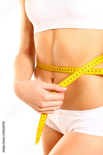 Athletic woman with measure tape on white background