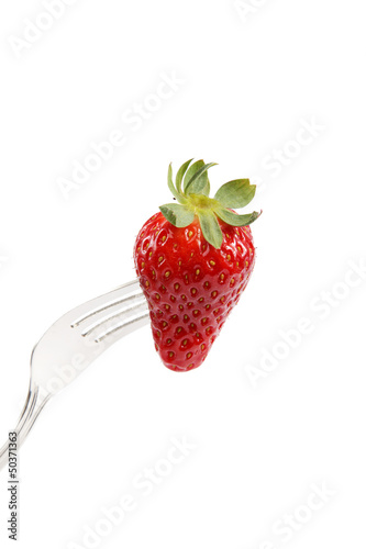 Strawberry on a fork isolated on white background.