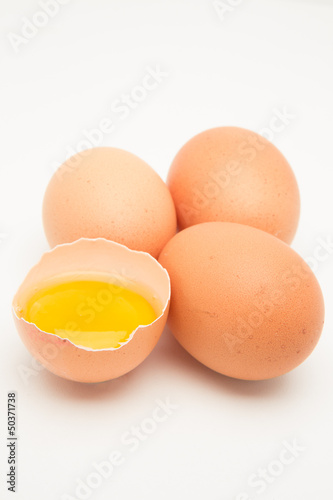 Three eggs with raw yolk in half a shell