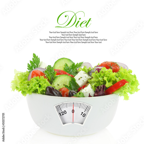 Diet meal. Vegetables salad in a bowl with weight scale photo