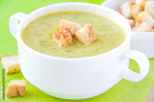 Zucchini cream soup with croutons in white cup