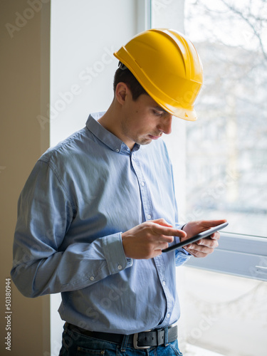 The builder in a helmet with a tablet