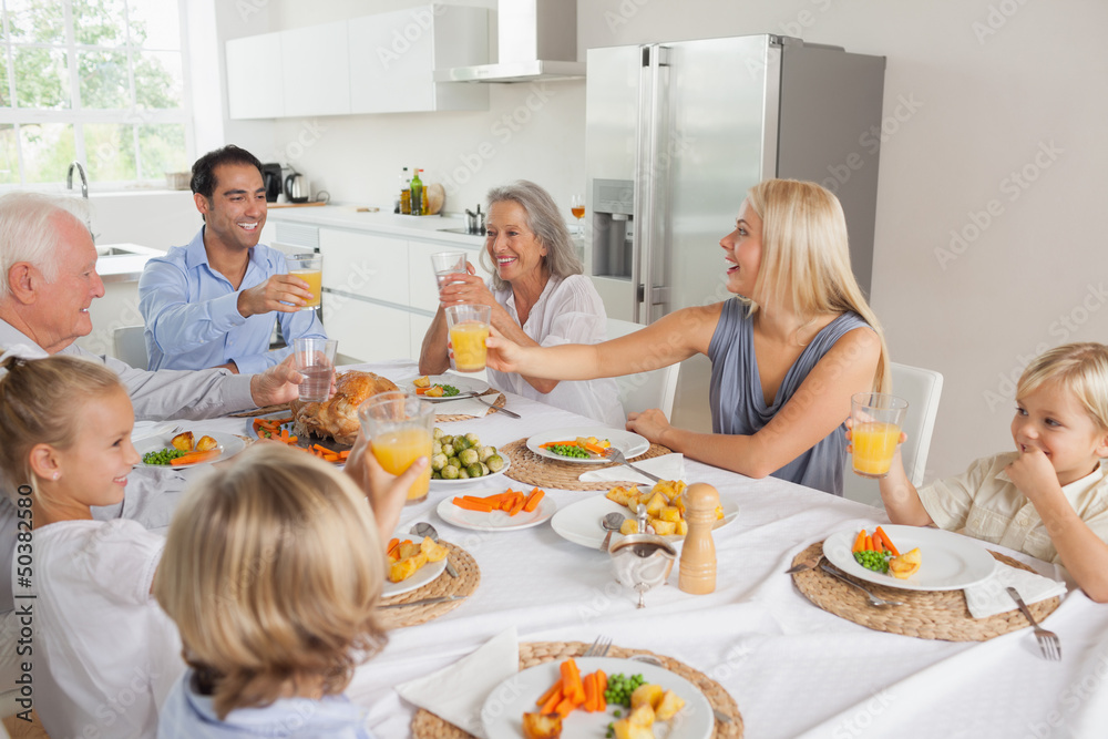 Smiling family raising their glasses together