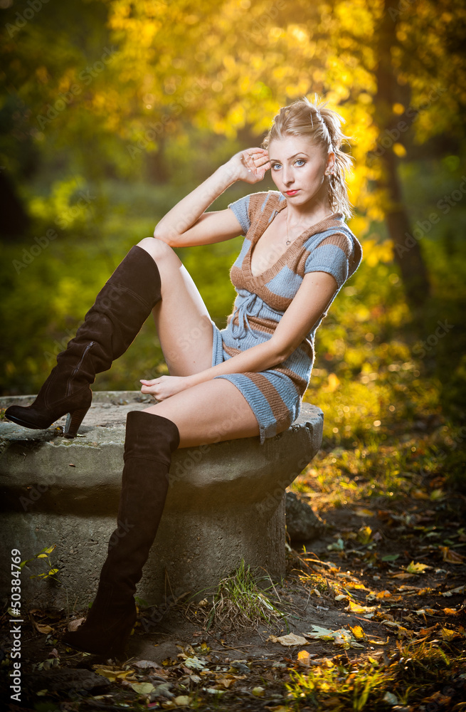 sexy girl with long leather boots and short dress in autumn park sexy girl with long leather boots and short dress in autumn park