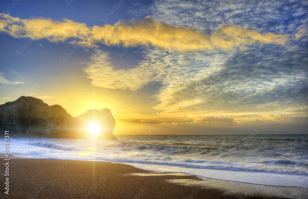 Vibrant sunrise over ocean with rock stack in foreground