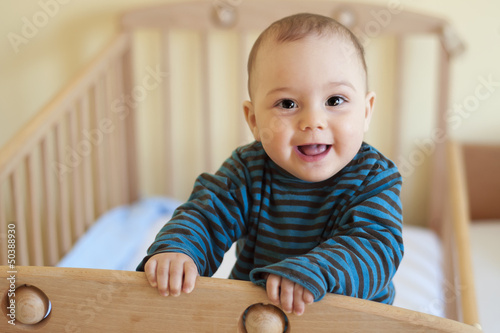 Baby standing in cot