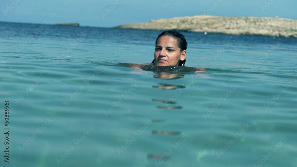 Beautiful woman swimming in the sea, slow motion shot at 120fps Beautiful woman swimming in the sea, slow motion shot at 120fps