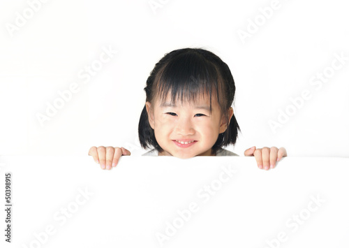 Asian little girl hiding behind white board