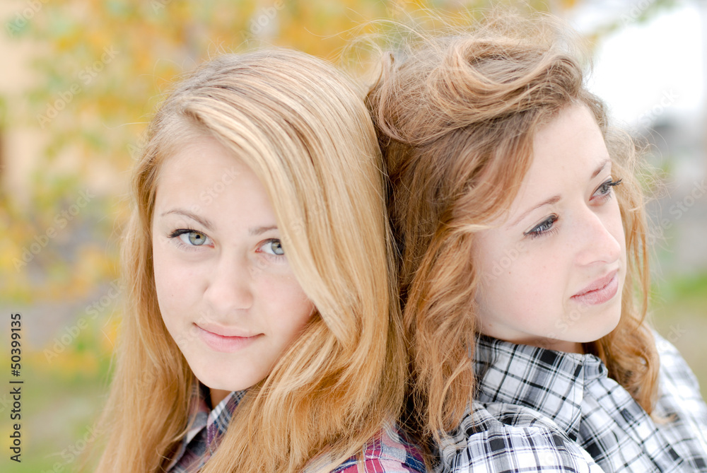 Two happy teen school girls friends outdoors
